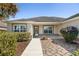 Inviting front entrance with a walkway, landscaped garden beds, and decorative stone accents at 3407 Melbourne Ln, The Villages, FL 32163