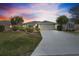 Well-maintained home with a manicured lawn and a concrete driveway at dusk at 3407 Melbourne Ln, The Villages, FL 32163