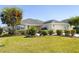 Charming home featuring a lush green lawn, mature landscaping, and decorative stone accents that add curb appeal at 3407 Melbourne Ln, The Villages, FL 32163