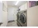 Convenient laundry room features modern washer and dryer units and overhead storage cabinets at 3407 Melbourne Ln, The Villages, FL 32163