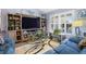 Comfortable living room features a modern entertainment center and shuttered windows, creating a bright and inviting space at 3407 Melbourne Ln, The Villages, FL 32163