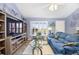 Bright living room with blue sofas, shuttered windows, and an entertainment center create a cozy and welcoming atmosphere at 3407 Melbourne Ln, The Villages, FL 32163