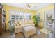 Bright living room featuring shuttered windows, a sofa with an ottoman, and built-in shelves at 3407 Melbourne Ln, The Villages, FL 32163