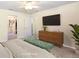 Serene main bedroom with a stylish dresser, TV, and closet access at 3407 Melbourne Ln, The Villages, FL 32163