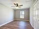 Bedroom features wood-look flooring, a ceiling fan, a window, and a closet with bi-fold doors at 4541 Se 30Th St, Ocala, FL 34480