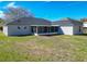 Rear exterior of home with enclosed screened patio and large lawn at 4541 Se 30Th St, Ocala, FL 34480
