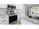 Close up of a modern kitchen with stainless steel appliances, granite countertops and white cabinets at 4541 Se 30Th St, Ocala, FL 34480