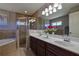 Bathroom with double sink vanity, framed mirror, tiled walls, soaking tub, and glass shower at 5037 Sw 109Th Loop, Ocala, FL 34476