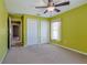 Bedroom with green walls, ceiling fan, carpet and two closets at 5037 Sw 109Th Loop, Ocala, FL 34476