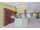 Well-lit kitchen with brown cabinetry, granite counters, a breakfast bar, and modern appliances at 5037 Sw 109Th Loop, Ocala, FL 34476