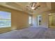 Main bedroom featuring carpeted floors, a ceiling fan, two windows, and an ensuite bathroom at 5037 Sw 109Th Loop, Ocala, FL 34476