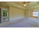 Main bedroom featuring carpet flooring, a ceiling fan, and access to an ensuite bathroom at 5037 Sw 109Th Loop, Ocala, FL 34476