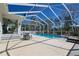 Backyard with a screened-in pool, patio, seating, and lush landscaping at 5037 Sw 109Th Loop, Ocala, FL 34476