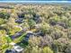 Aerial view of a home surrounded by mature trees in a quiet neighborhood at 5150 Se 47Th Court Rd, Ocala, FL 34480