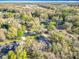 Aerial view of a home surrounded by mature trees and lush greenery in a quiet neighborhood at 5150 Se 47Th Court Rd, Ocala, FL 34480