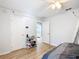 Bright bedroom with light wood floors, ceiling fan, shoe rack, and access to walk-in closet and bathroom at 5150 Se 47Th Court Rd, Ocala, FL 34480
