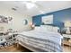 Inviting bedroom featuring a queen-size bed, wood floors, a blue accent wall, and a ceiling fan at 5150 Se 47Th Court Rd, Ocala, FL 34480