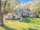 Charming exterior elevation showcasing a well-manicured lawn and mature trees at 5150 Se 47Th Court Rd, Ocala, FL 34480