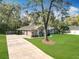 Exterior view of home with long driveway and lush front yard at 5150 Se 47Th Court Rd, Ocala, FL 34480
