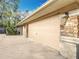 A side view of a multi-car garage with stone accents and exterior lighting at 5150 Se 47Th Court Rd, Ocala, FL 34480