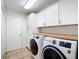 Bright laundry room with butcher block countertop, white cabinets, and modern washer/dryer at 5150 Se 47Th Court Rd, Ocala, FL 34480