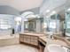 Well-lit main bathroom featuring a tub, large mirrors, and double sink vanity with natural colors at 5150 Se 47Th Court Rd, Ocala, FL 34480