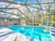 A screened-in pool features a waterfall, patio and lush outdoor scenery at 5150 Se 47Th Court Rd, Ocala, FL 34480