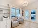Bright sitting area featuring tile floors, shelving, chandelier, and chairs with view of backyard at 5150 Se 47Th Court Rd, Ocala, FL 34480