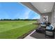 Covered patio with chairs and a table overlooking a vast green space at 5270 Nw 33Rd Pl, Ocala, FL 34482