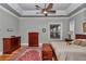 Large bedroom with tray ceilings, crown molding, hardwood floors, and a ceiling fan at 5560 Ne 31St Ter, Ocala, FL 34479