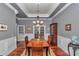 Light-filled dining room with coffered ceilings, hardwood floors, and french doors to the rear of the home at 5560 Ne 31St Ter, Ocala, FL 34479