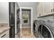 Pass through laundry room with washer, dryer, refrigerator, and storage cabinets at 5560 Ne 31St Ter, Ocala, FL 34479