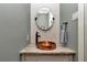 Charming powder room with unique copper sink, oval mirror and decorative tile at 5560 Ne 31St Ter, Ocala, FL 34479