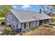 Home's rear view reveals light gray vinyl siding and a vast backyard surrounded by lush landscaping and fencing at 5560 Ne 31St Ter, Ocala, FL 34479