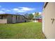 Spacious backyard with lush green grass, a storage shed, and the rear of the house, perfect for outdoor activities at 5615 Se 113Th Pl, Belleview, FL 34420
