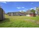 View of home with spacious backyard and storage sheds, perfect for outdoor activities at 5615 Se 113Th Pl, Belleview, FL 34420
