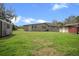 Backyard featuring green grass, a storage shed, and open space for outdoor enjoyment at 5615 Se 113Th Pl, Belleview, FL 34420