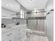 Modern bathroom with double vanity, marble countertop, and walk-in shower at 5615 Se 113Th Pl, Belleview, FL 34420