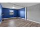 Bedroom with laminate flooring, large window, neutral color walls, and baseboard trim at 5615 Se 113Th Pl, Belleview, FL 34420