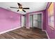 A bedroom with hardwood floors, closet with built-ins, and an open doorway at 5615 Se 113Th Pl, Belleview, FL 34420