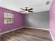 This bedroom has hardwood floors, a ceiling fan, and a window at 5615 Se 113Th Pl, Belleview, FL 34420