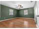 Comfortable bedroom with wood flooring, two bright windows, and a ceiling fan at 5615 Se 113Th Pl, Belleview, FL 34420