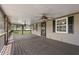 Inviting screened-in porch featuring a wooden floor, ceiling fans, and views of the surrounding yard at 5615 Se 113Th Pl, Belleview, FL 34420