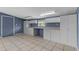 A well-lit utility room with tile flooring, built-in storage cabinets, and a view to the exterior at 5615 Se 113Th Pl, Belleview, FL 34420