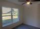 Bright and airy bedroom featuring neutral walls, wood-look floors, and a ceiling fan at 74 Fisher Terrace, Ocklawaha, FL 32179