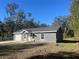 Charming single-story home featuring a gray stucco exterior, garage, and freshly poured driveway at 74 Fisher Terrace, Ocklawaha, FL 32179