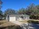 Charming single-story home featuring a one-car garage and a spacious concrete driveway at 74 Fisher Terrace, Ocklawaha, FL 32179