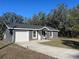Charming single-story home featuring a one-car garage and a spacious concrete driveway at 74 Fisher Terrace, Ocklawaha, FL 32179