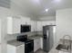 Modern kitchen with white cabinets, granite countertops, and stainless steel appliances at 74 Fisher Terrace, Ocklawaha, FL 32179
