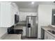 Well-equipped kitchen with stainless steel appliances, granite countertops, and white cabinets at 74 Fisher Terrace, Ocklawaha, FL 32179